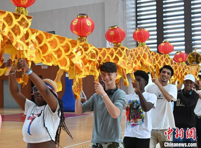 中国侨网8月1日，在黄山学院，美国青年和该校学生一起体验舞动板凳龙。7月30日至8月1日，来自美国马里兰州的高中生研学团一行在安徽黄山开启徽州之旅，在文化交流间尽显情谊。中新社记者 韩苏原 摄