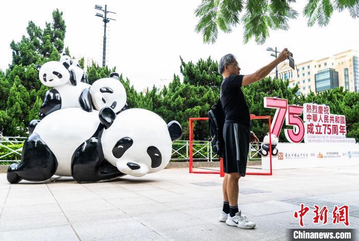 中国侨网10月5日，香港维多利亚公园一隅摆放的大熊猫雕塑吸引市民在此拍照“打卡”留念。此前，第三对中央赠港大熊猫已顺利抵达并入住香港海洋公园；海洋公园内诞生的一对大熊猫幼崽目前也在健康成长中。中新网记者 侯宇 摄　 