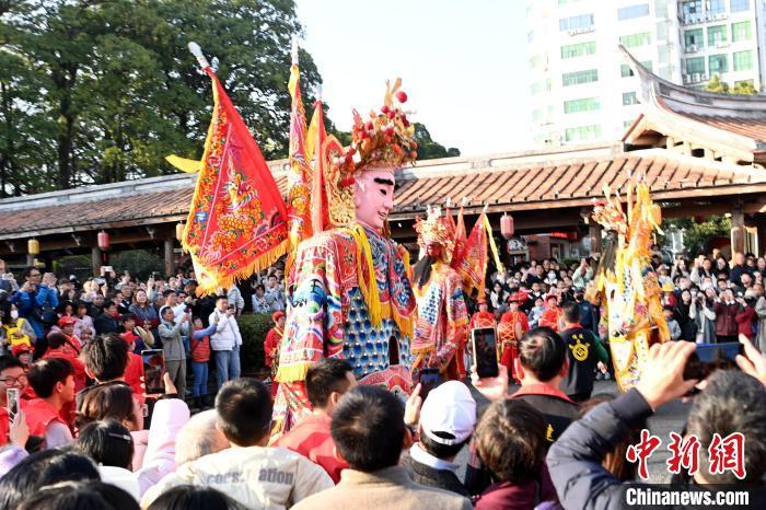 中国侨网2月4日，福建漳州古城热闹非凡，非遗民俗表演吸引不少游客驻足观赏拍照。这个春节，漳州古城举办了“闽南过大年”为主题的新春嘉年华活动，除夕至十五，六大单元上百场活动精彩不断。其中，13 场非遗民俗表演更是将节日气氛推向高潮。图为游客驻足观赏非遗民俗表演。中新社记者 张金川 摄