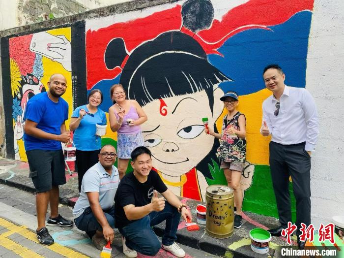 中国侨网当地时间3月16日,毛里求斯唐人基金会联合当地艺术家杰·拉姆朱南(Jay Ramjunun)创作的“哪吒”墙绘正式完成,成为路易港唐人街一道亮丽的风景线。该壁画长3米,高2米,以中国动画电影《哪吒之魔童闹海》中的“哪吒”形象为参考,用红、蓝、黄、绿四种颜色作为底色。“哪吒”墙绘现身毛里求斯,让传统唐人街焕发时代活力。图为创作者们在路易港唐人街“哪吒”墙绘前合影。毛里求斯唐人街基金会供图