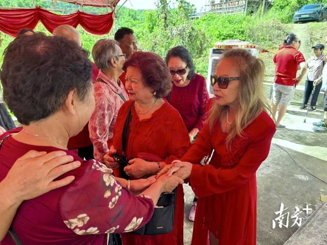 当张芳霞搀扶80多岁的母亲走到祠堂门口时，亲戚围了过来，拉着她们的手亲切地问候。