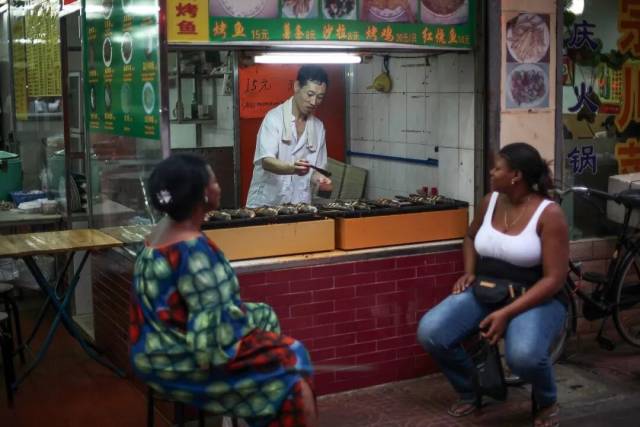 ▲广州宝汉直街，两位女士在餐厅外等待非洲烤鱼 图/南方人物周刊记者 方迎忠